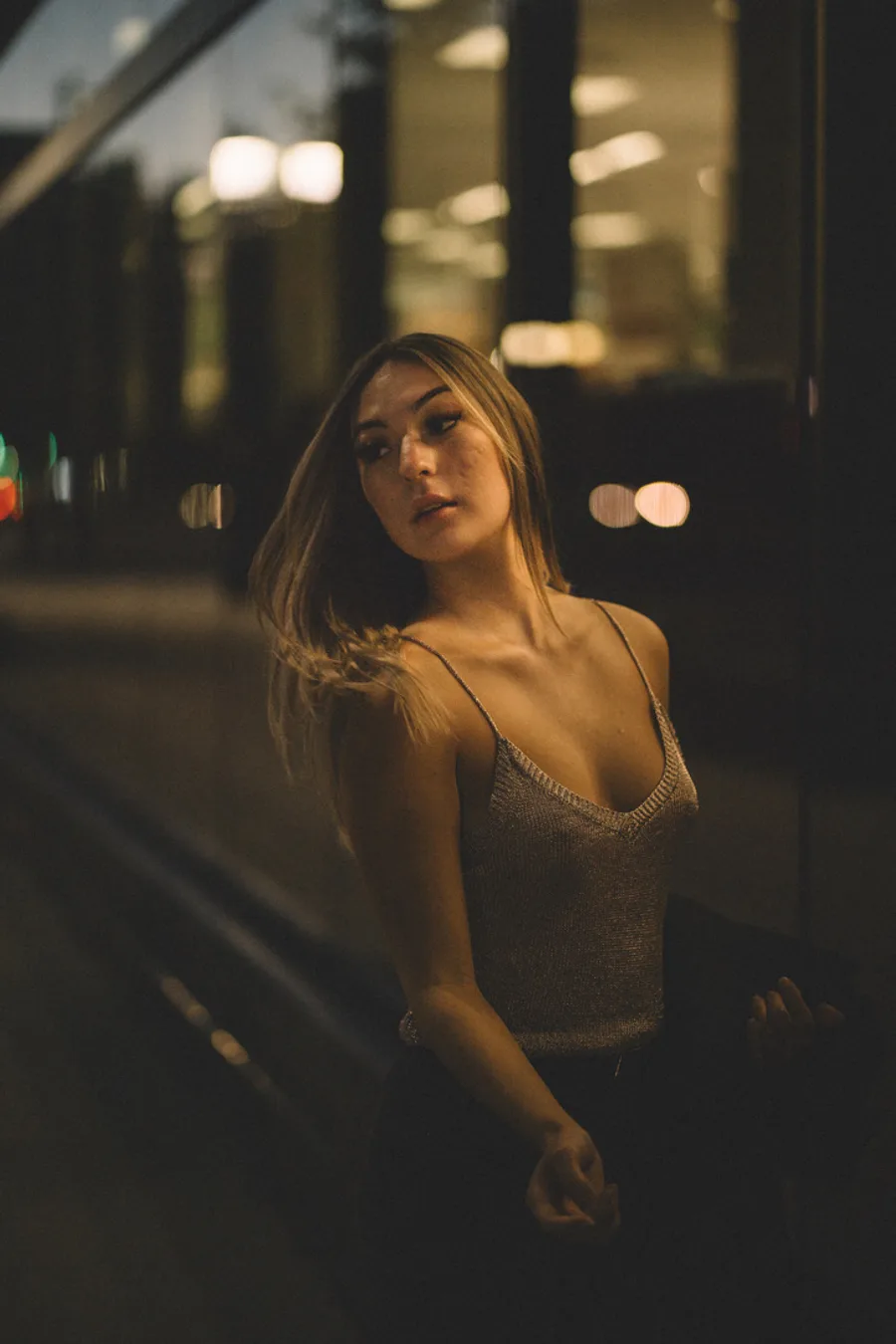 Dusk portrait of a woman downtown with city lights behind her